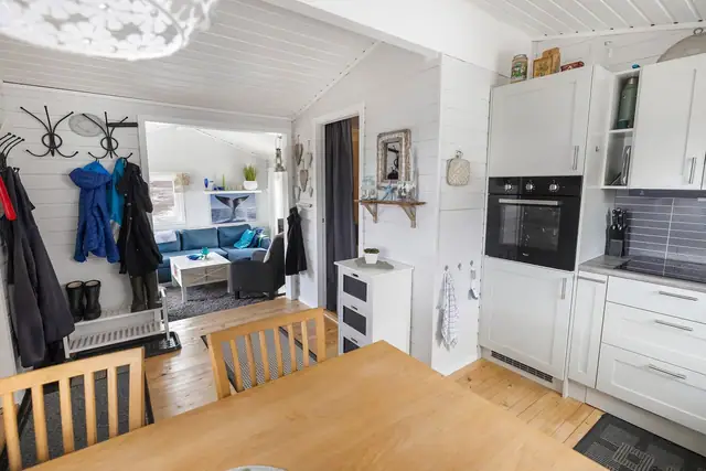 Åpen løsning mellom kjøkken og spiseplass skaper en sosial sone.