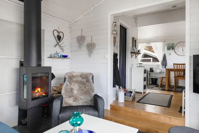Stuen er et lunt samlingspunkt med et effektivt ildsted for varme.