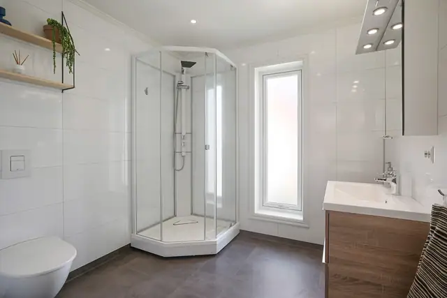 Badet er utstyrt med toalett og dusjkabinett.