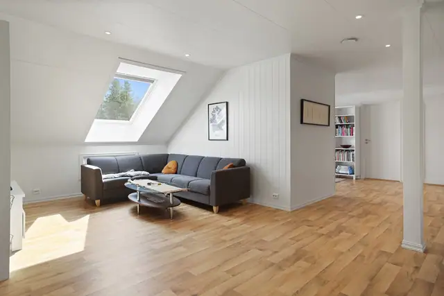Romslig loftstue med takvindu som gir en lys og luftig følelse.