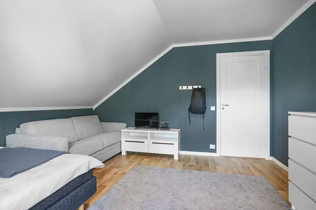Ett av soverommene i loftsetasjen, med plass til seng og møblement.