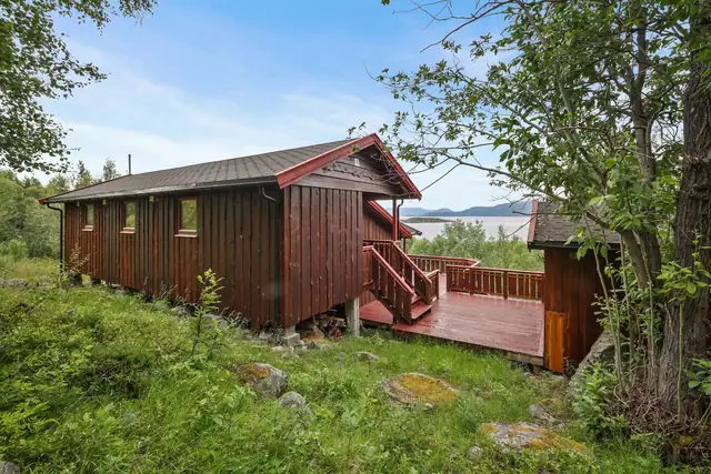 Hytta ligger fint til i terrenget med omkransende natur.