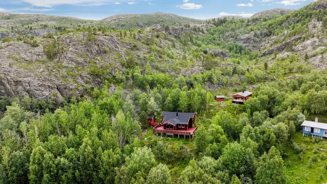 Eiendommen ligger i et spredt hyttefelt omgitt av skog.
