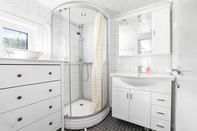 Badet har en lys innredning med varme i gulvet.